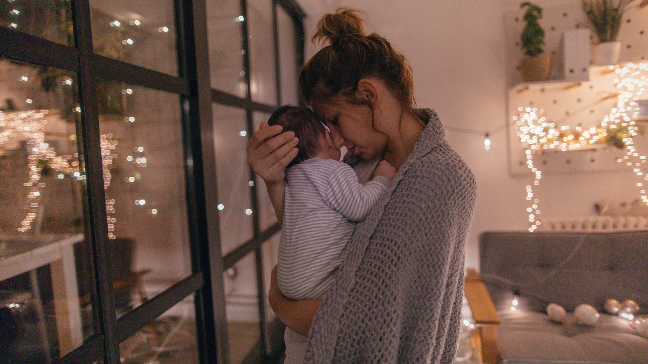 woman holding newborn trying to help it sleep at night